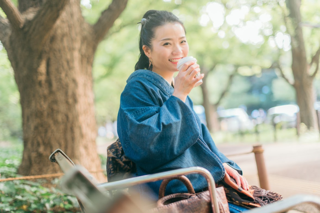 公園のベンチでデニム着物を楽しむ鈴木悠美子
